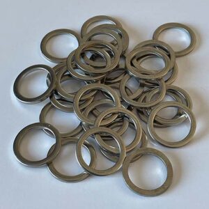 A pile of Pedal Spacer Washers scattered on a white surface.