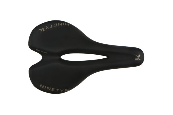 Black bicycle saddle with "ninety k" branding and a cut-out center, isolated on a white background.
