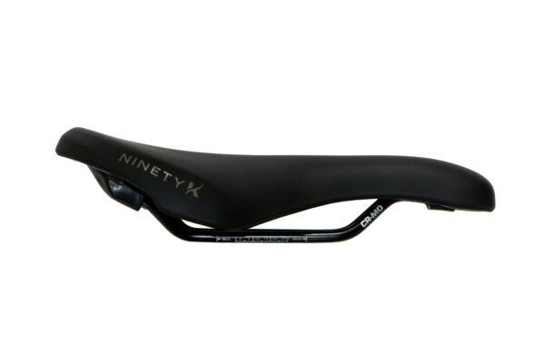 Black racing bicycle saddle with "ninetyx" and "carbon" branding on a white background.