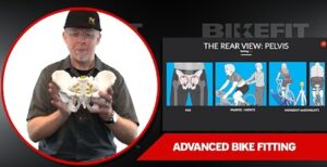 A man holds a pelvic model next to bike fitting diagrams with the text "Advanced Bike Fitting" at the bottom.